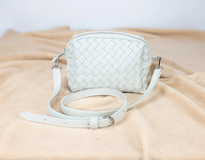 White woven handbag on a beige fabric background