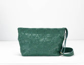 Green textured handbag with a strap on a white background