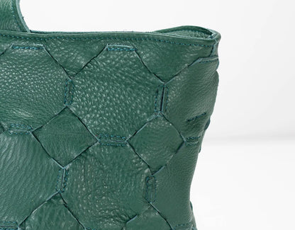 Close-up of a green textured handbag on a white background
