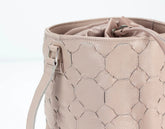 Beige handbag with hexagonal pattern on a white background