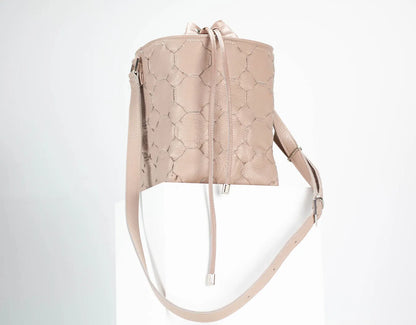 Beige quilted handbag with drawstring on a light gray background