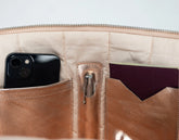 Close-up of a beige leather wallet with a phone and card holder.