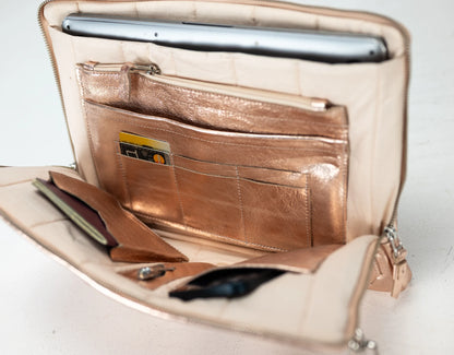 Open beige handbag with metallic accents on a white background