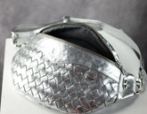 Silver woven handbag with a zipper on a gray background