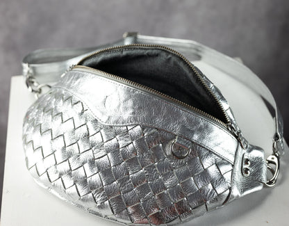 Silver woven handbag with a zipper on a gray background
