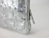 Silver textured clutch bag on a light gray background