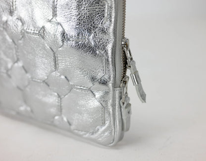 Silver textured clutch bag on a light gray background