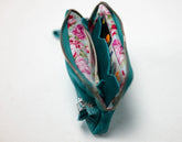 Green leather wristlet with a zipper on a white background