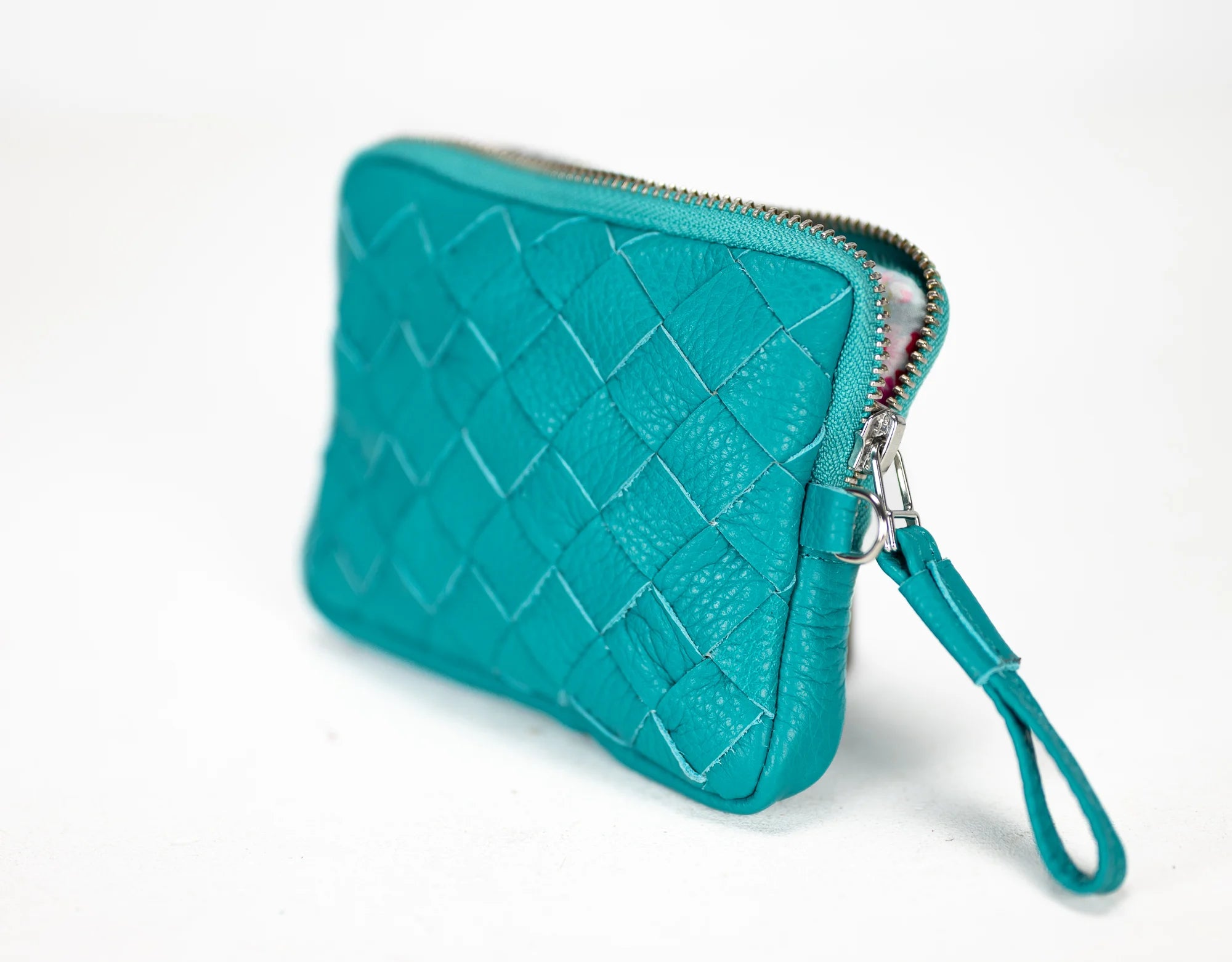 Teal quilted clutch with a strap on a white background