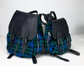 Two backpacks with plaid pattern and black leather accents on a white background