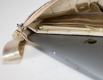 Gold handbag with a laptop inside on a white background