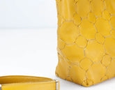 Yellow textured handbag on a light gray background