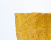 Yellow woven clutch bag on a white background