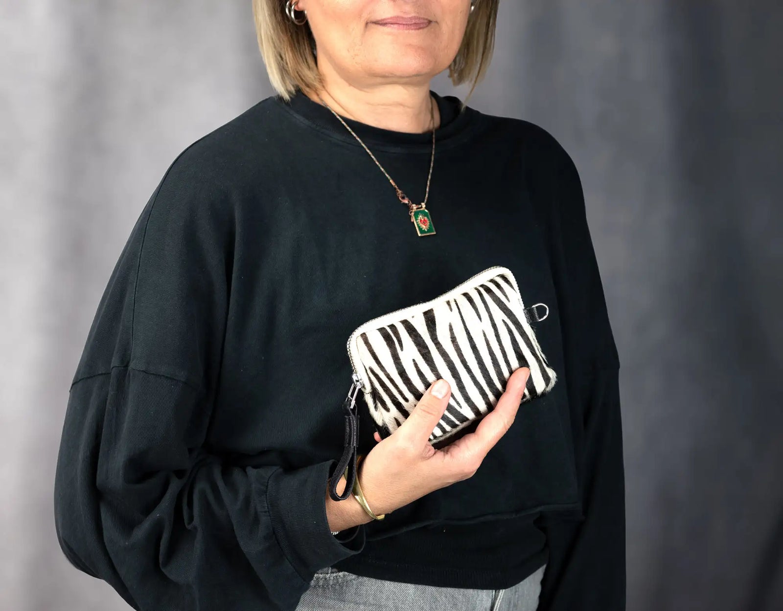 Zebra-patterned handbag with a visible zipper on a white background