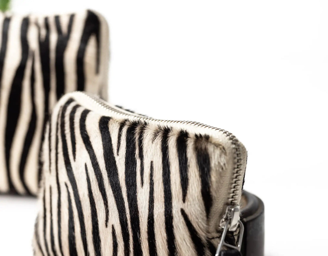 Zebra-patterned handbag with a visible zipper on a white background