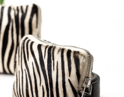 Zebra-patterned handbag with a visible zipper on a white background