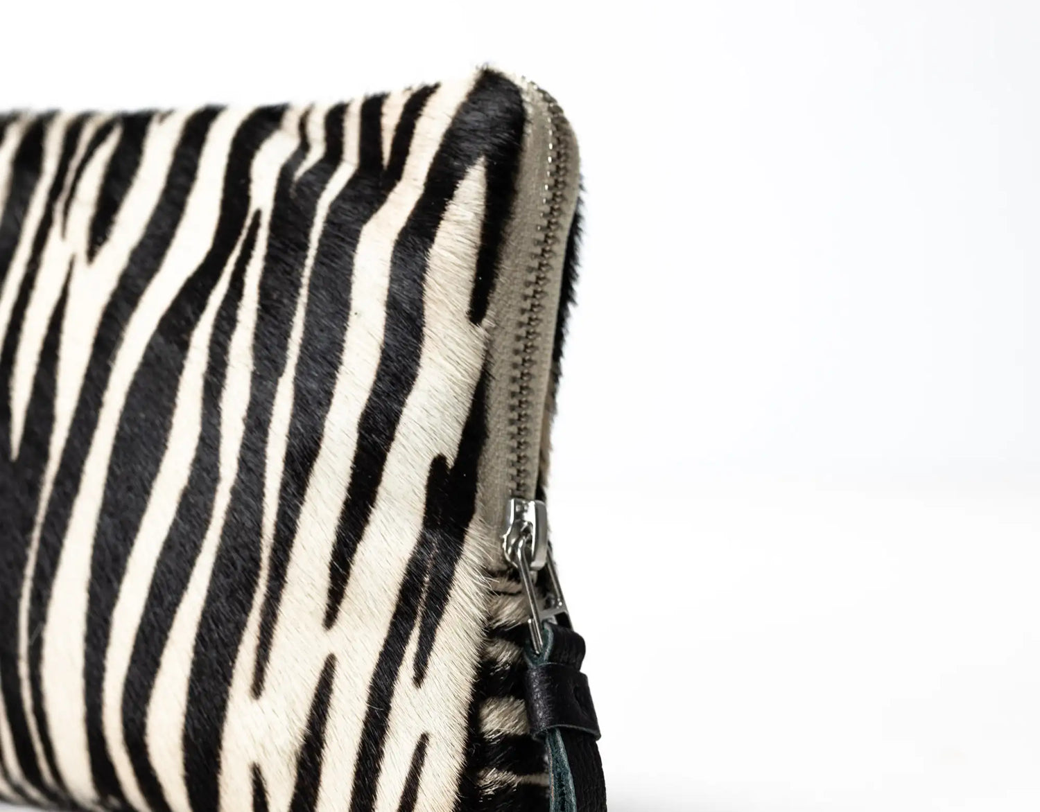 Zebra-patterned pouch with a zipper on a white background