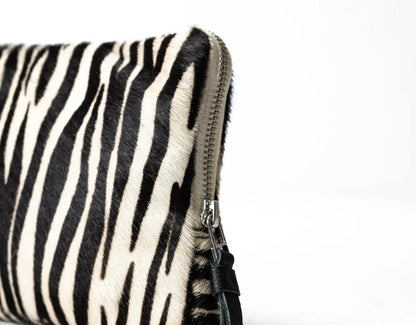Zebra-patterned pouch with a zipper on a white background