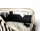 Close-up of a zipped pouch with black interior pocket on a white background