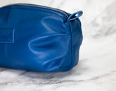 Blue leather pouch on a marble surface
