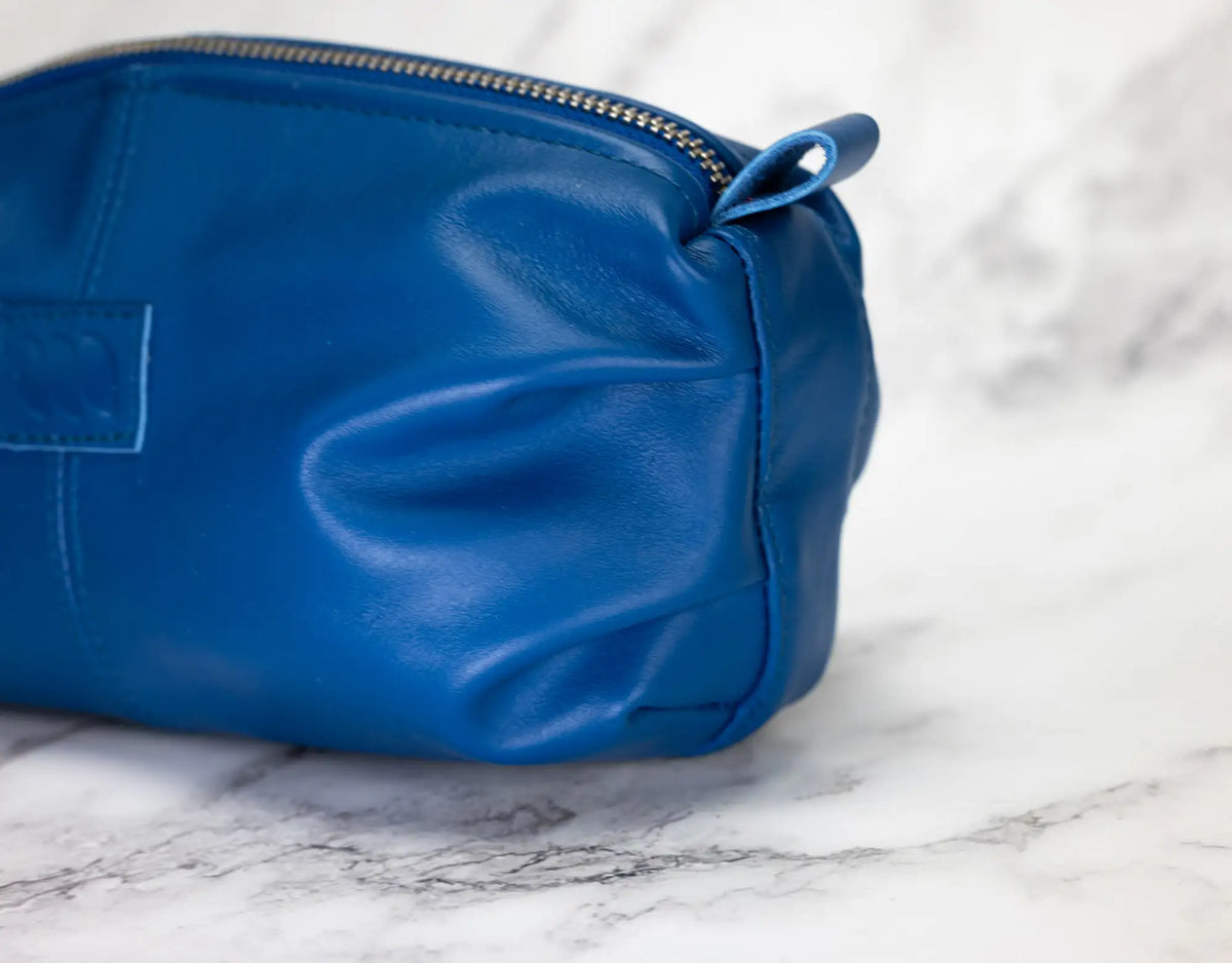 Blue leather pouch on a marble surface#color_royal-blue