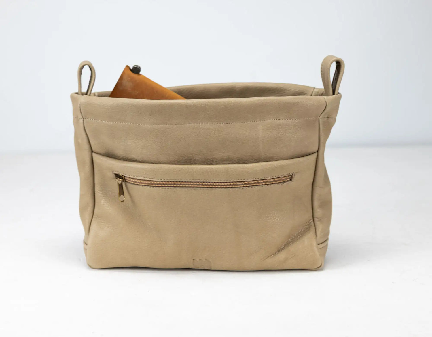 Beige leather bag with a zipper pocket on a white background
