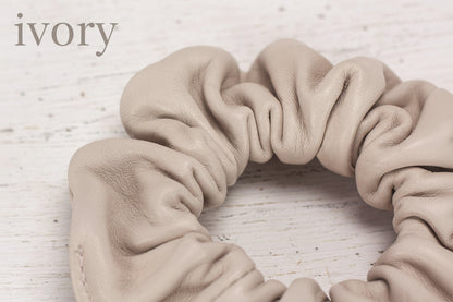 Beige scrunchie on a light wooden surface