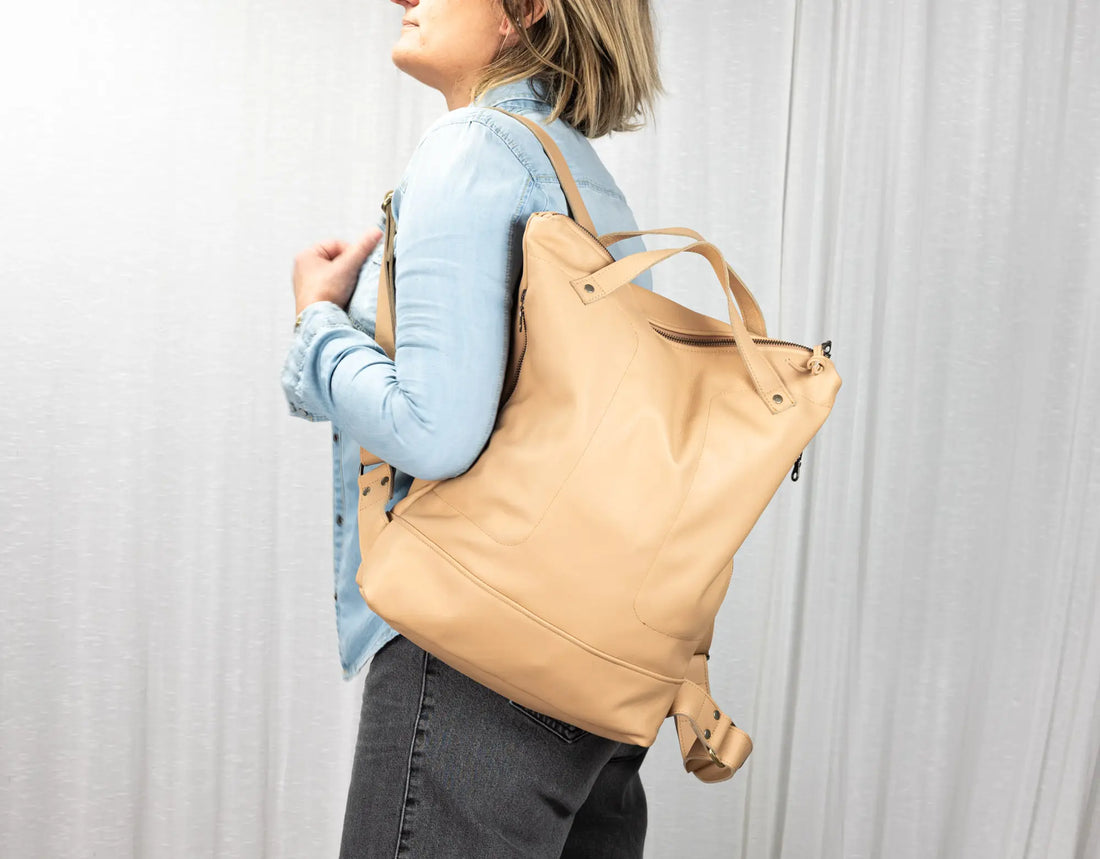 Person wearing a beige backpack against a plain background