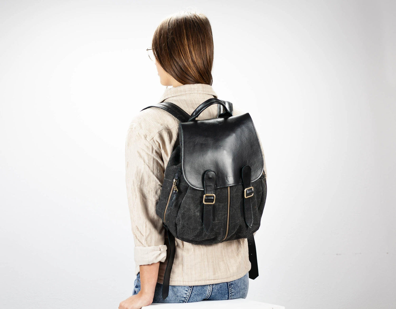 Person wearing a black backpack on a white background