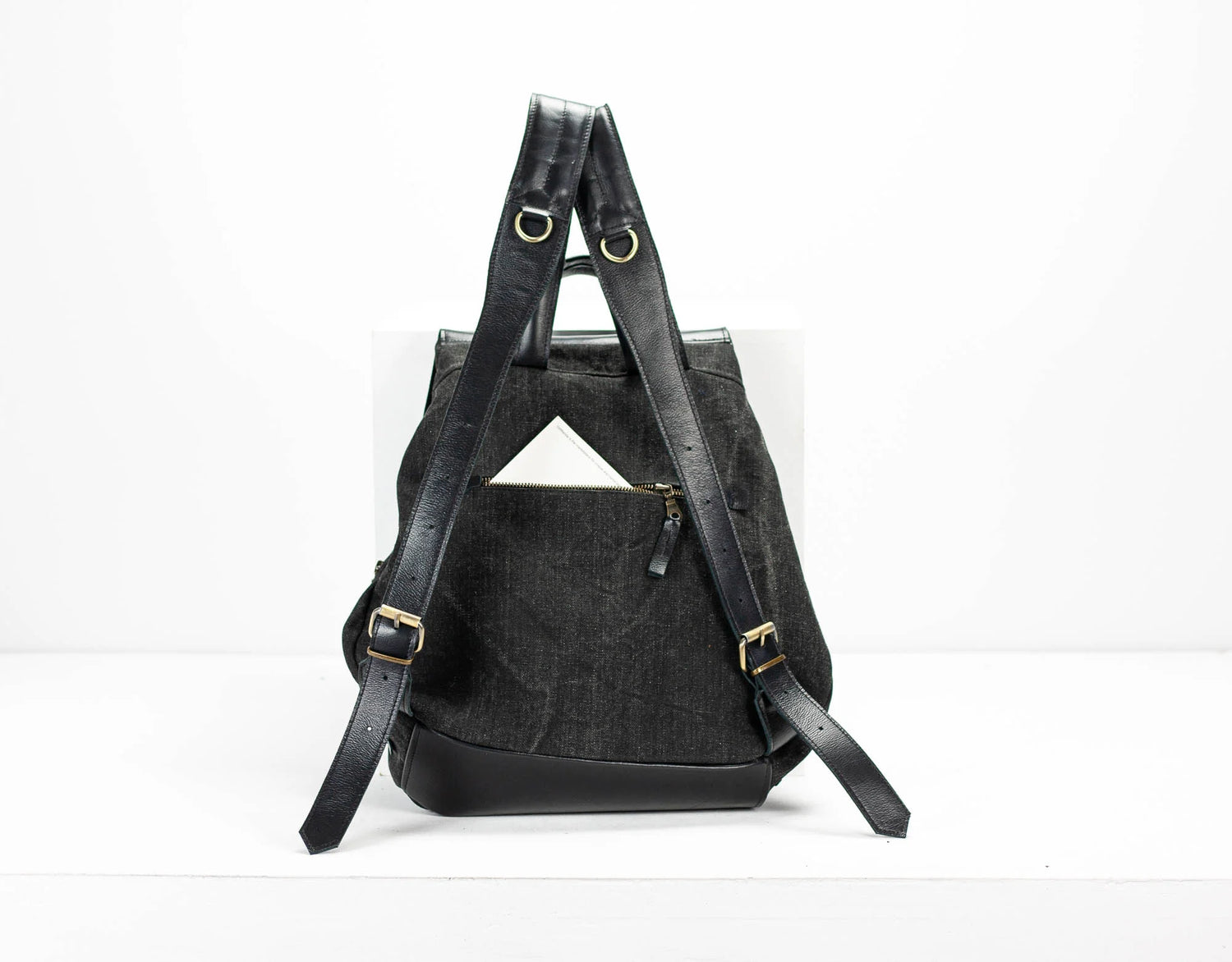 Black backpack with gold buckles on a white background