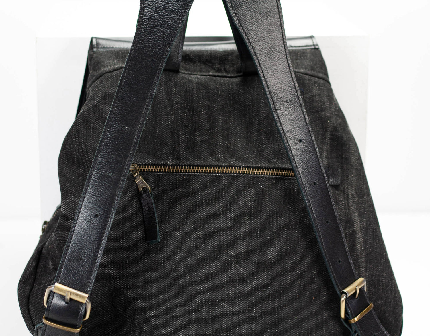 Black backpack with gold zippers and buckles on a white background