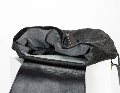 Black leather bag with a gray interior on a white background