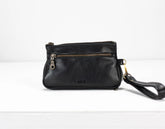 Black leather wristlet with a strap on a white background