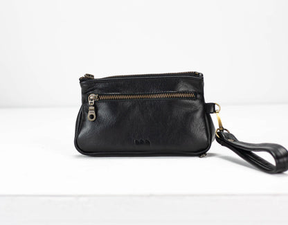 Black leather wristlet with a strap on a white background