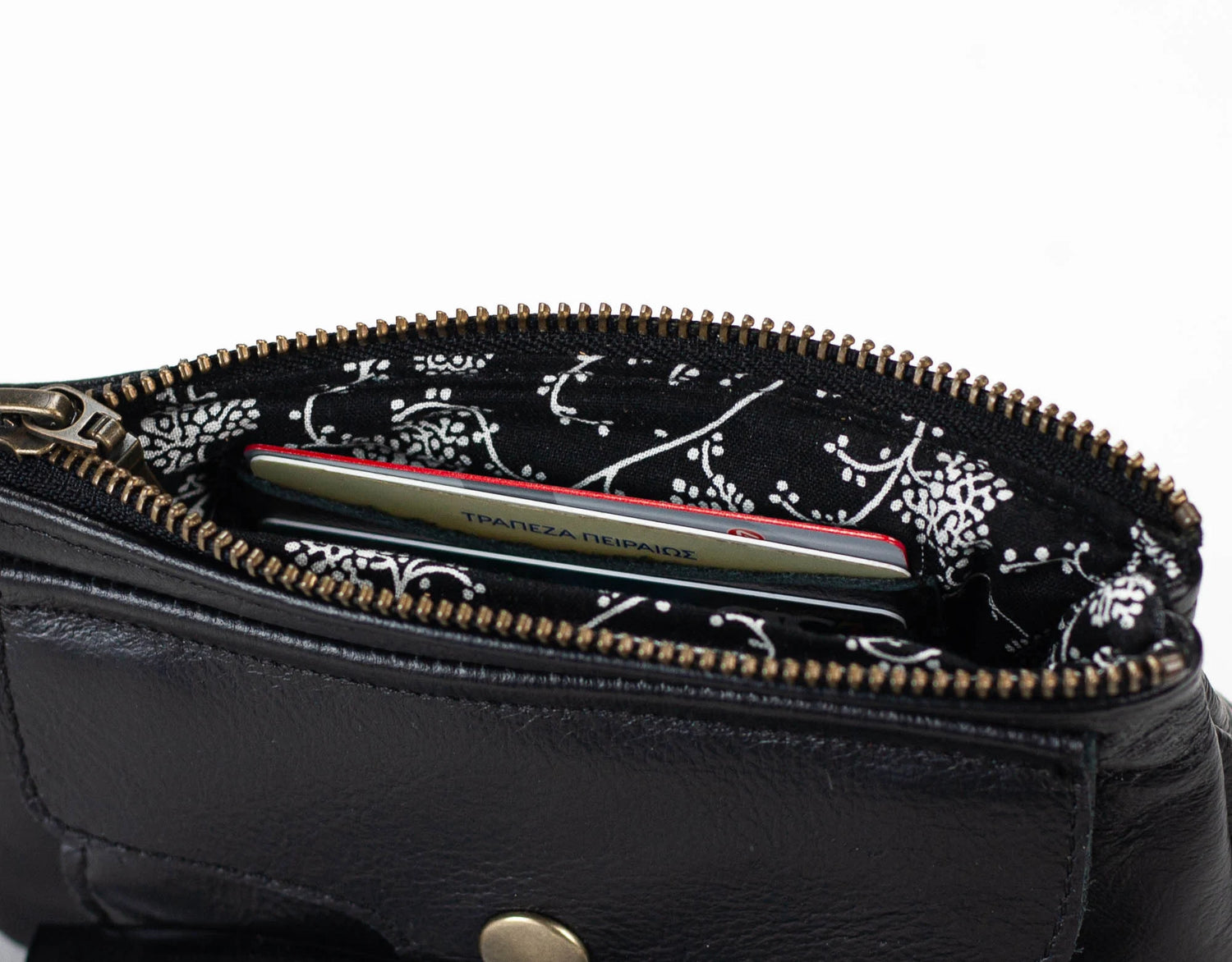 Black leather pouch with floral zipper pull on a white background