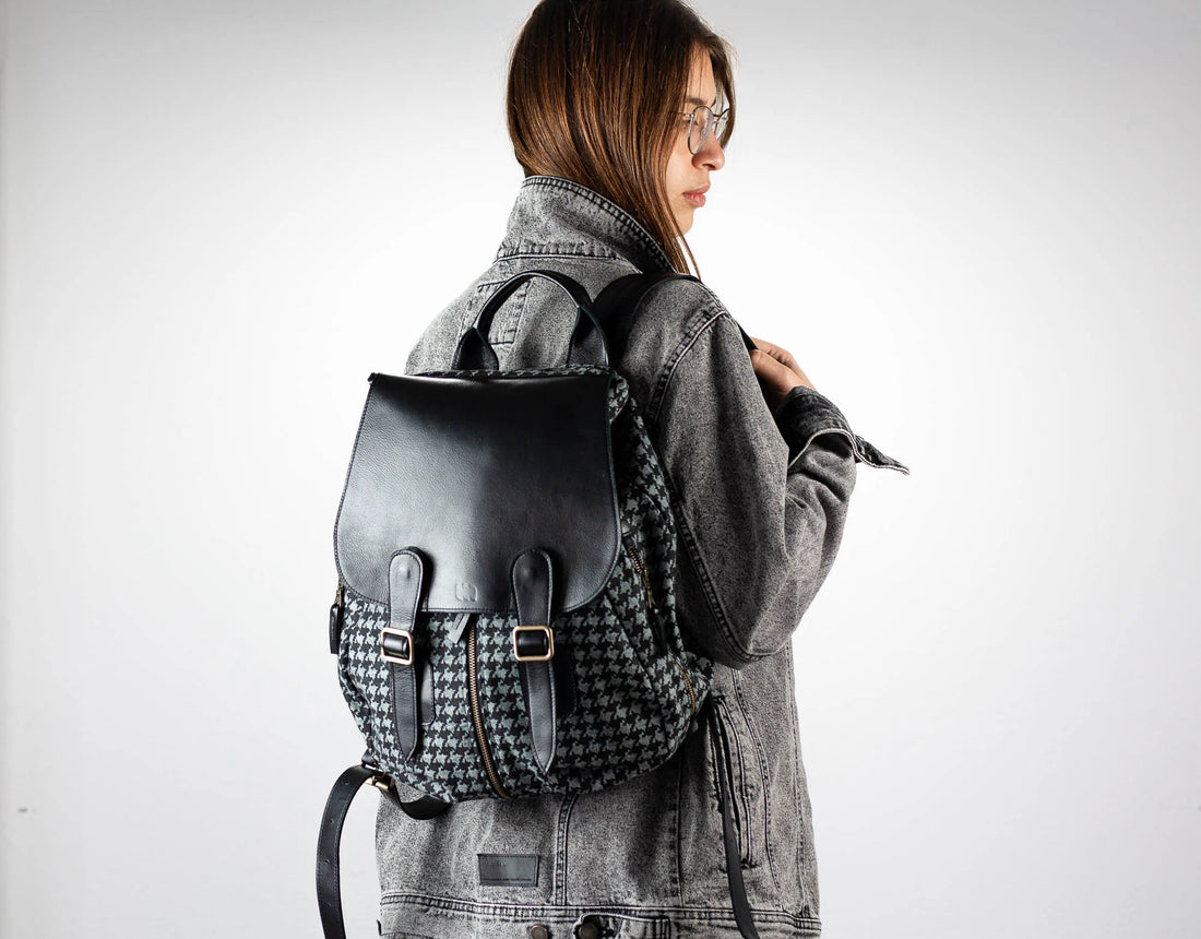 Person wearing a houndstooth pattern backpack with a plain background