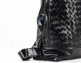 Black woven leather bag with a white background