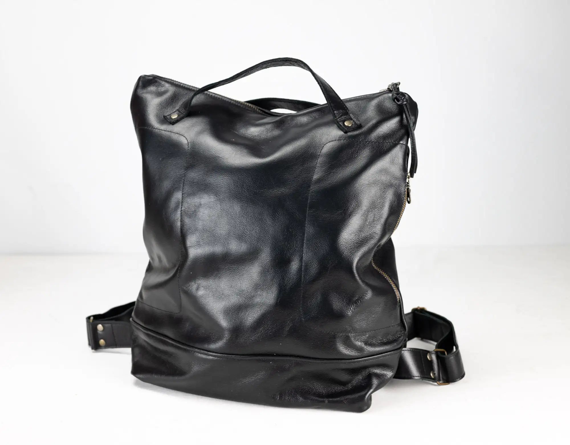 Black leather backpack on a white background