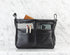 Black leather bag insert with compartments on a white textured background