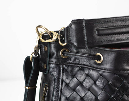 Black quilted leather handbag with gold hardware on a white background