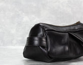 Black leather handbag on a light gray background