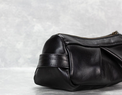Black leather handbag on a light gray background