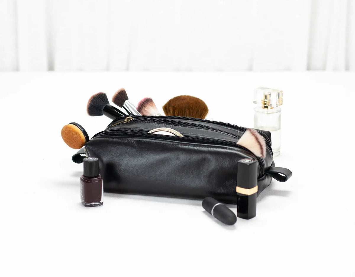 Black makeup bag with various cosmetic items on a white background#color_black