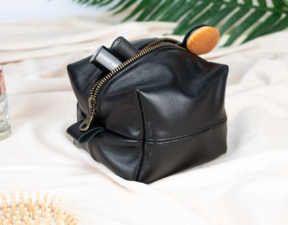 Black leather pouch with a zipper on a light background