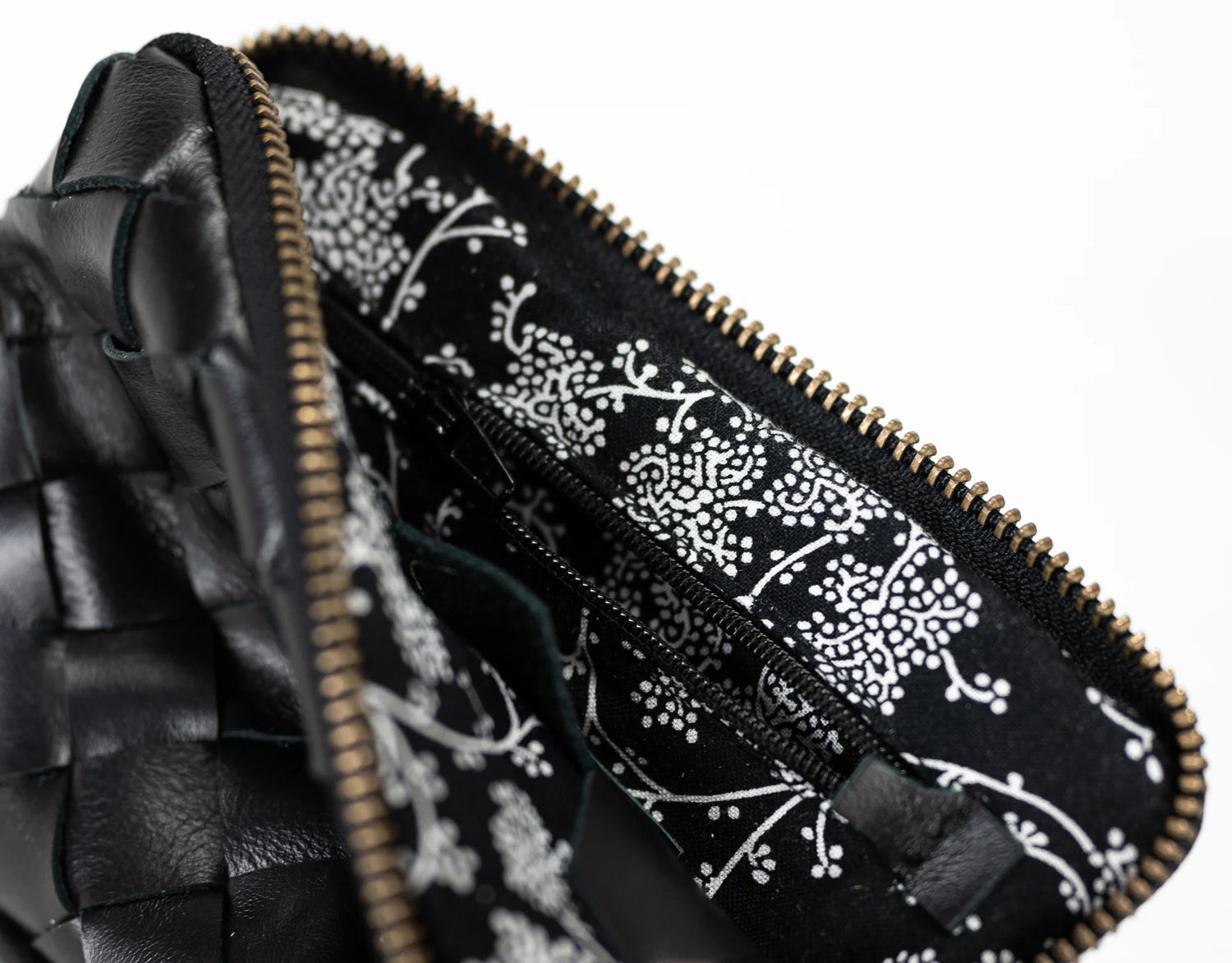 Close-up of a black leather pouch with a floral pattern on the interior lining.