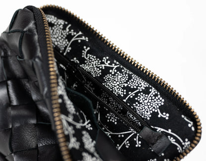 Close-up of a black leather pouch with a floral pattern on the interior lining.