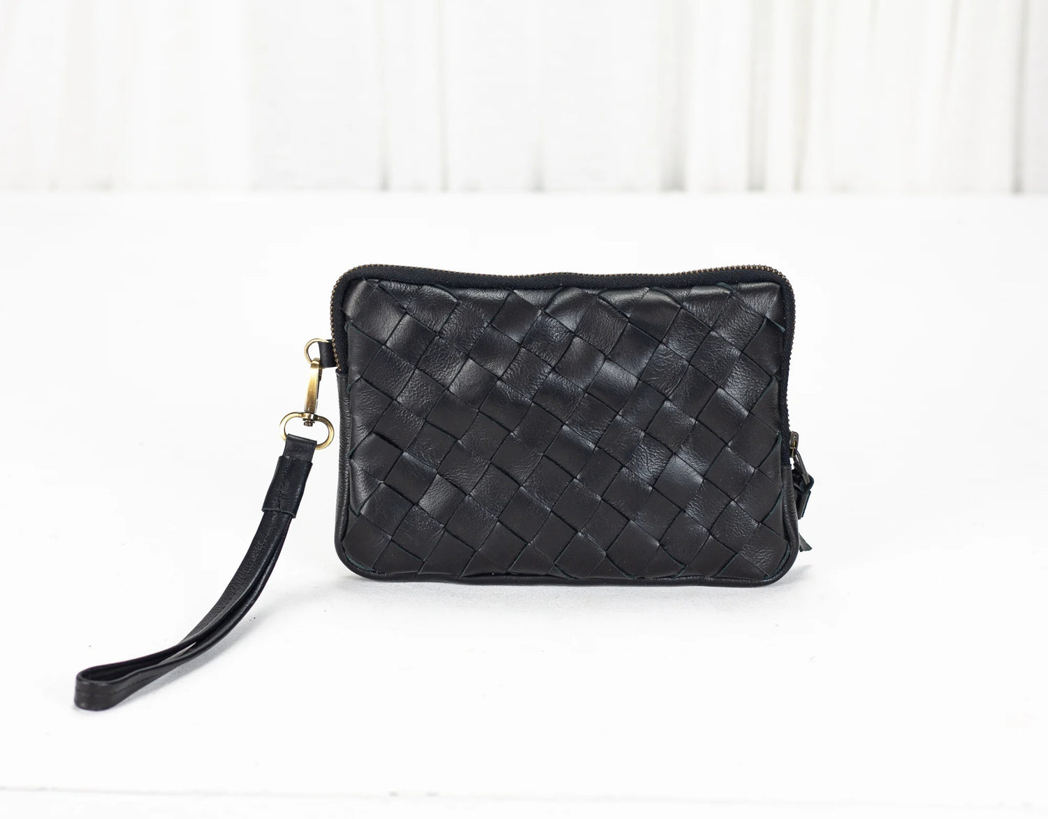 Black woven handbag on a white background