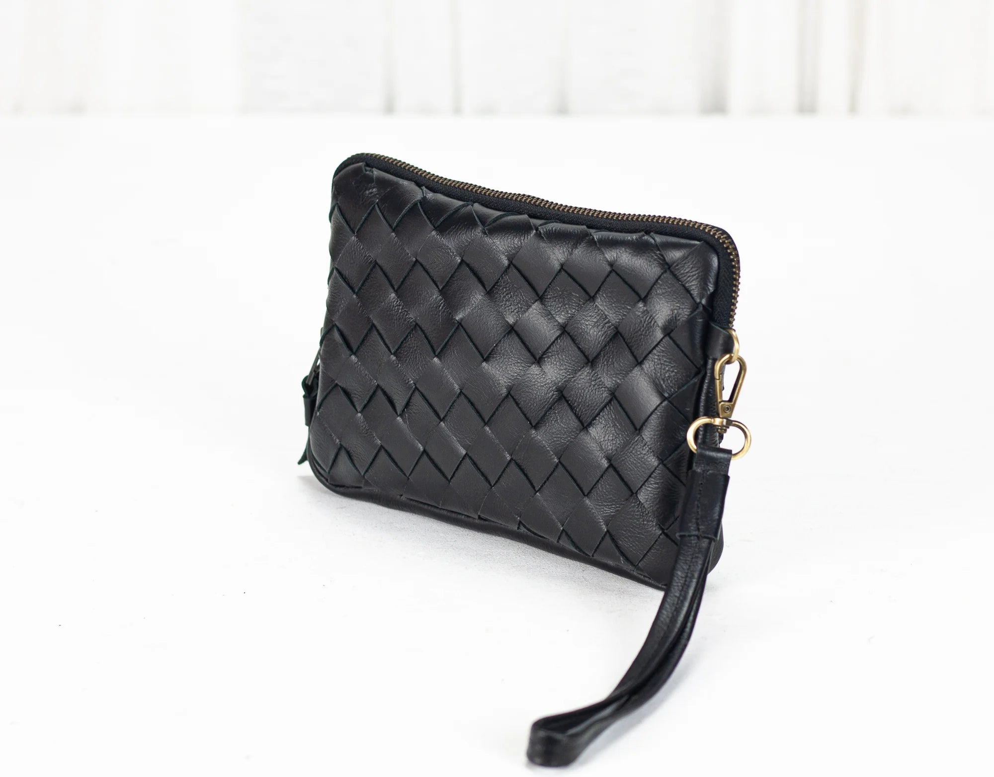 Black woven clutch bag on a white background
