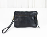 Black leather clutch bag with a strap on a white background