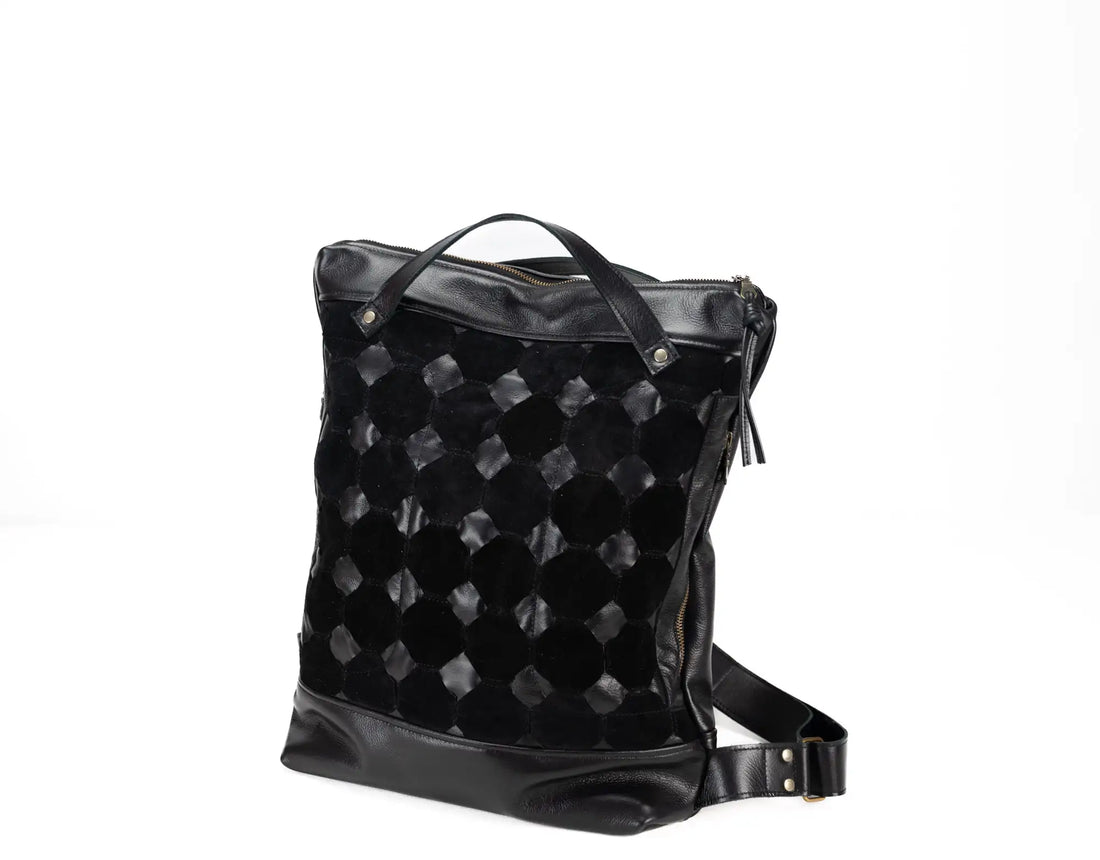 Black quilted backpack on a white background